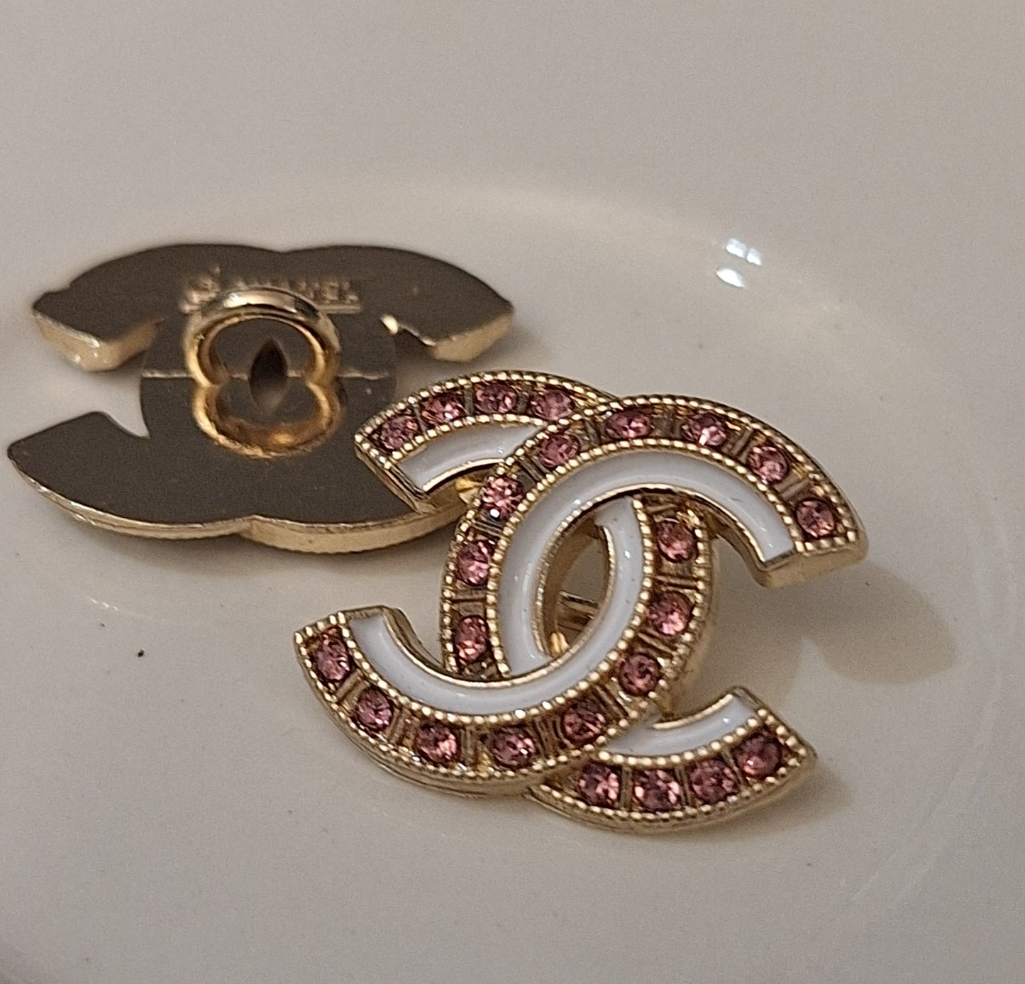 Buttons stamped. Gold, white enemal, pink zircon. 18/22 mm